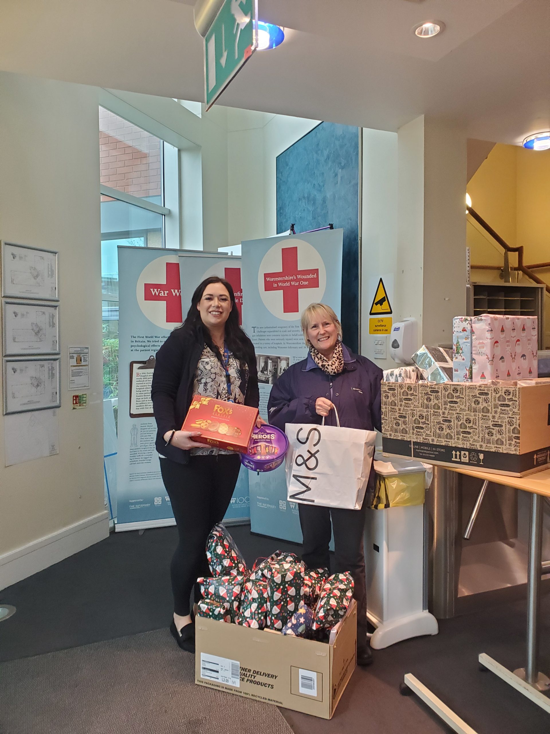 Two Roxel UK employees with Christmas presents and bags to give to charity.